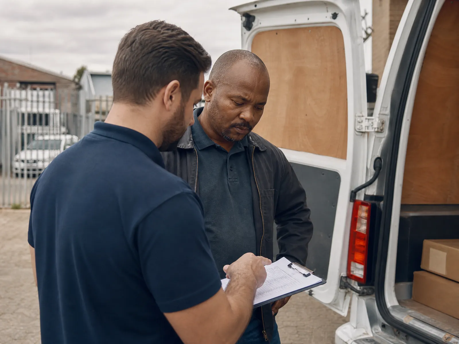 An MK Global consultant goes through a cost worksheet with an owner-driver at the back of his van.